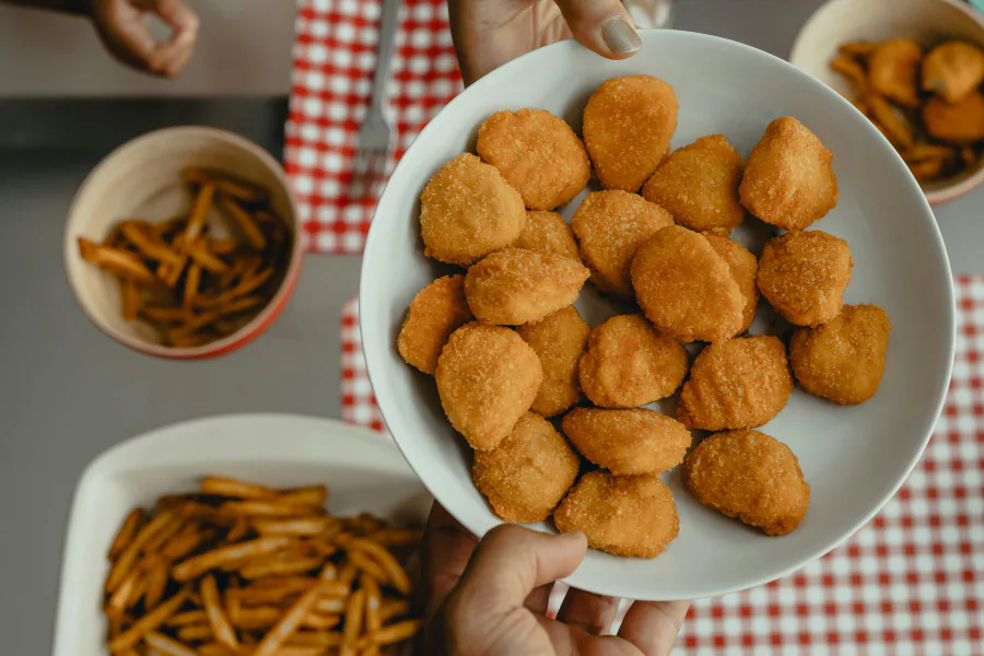 A plate of golden nuggets served with fries